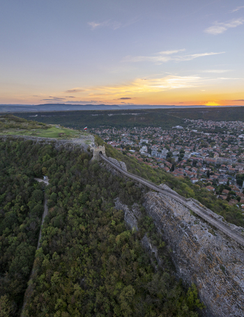 Aerial view of the historic Ovech Fortress perched on a cliffside overlooking the town of Provadia at sunset with stone walls and lush greenery in Provadia Varna Bulgaria. Aerial view of the historic Ovech Fortress perched on a cliffside overlooking the town of Provadia at sunset with stone walls and lush greenery in Provadia Varna Bulgaria.