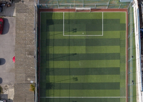 Aerial view of a soccer field with green artificial turf white markings and surrounding fencing in Istanbul Istanbul Turkiye.