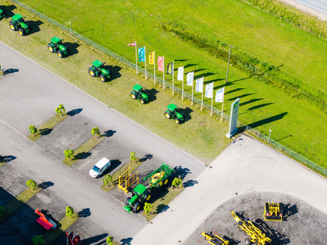 Kekava Latvia 05 July 2026 Aerial view of a John Deere agricultural machinery dealership with rows of green tractors on a lawn colorful flags and equipment in a paved lot. Kekava Latvia 05 July 2026 Aerial view of a John Deere agricultural machinery dealership with rows of green tractors on a lawn colorful flags and equipment in a paved lot.