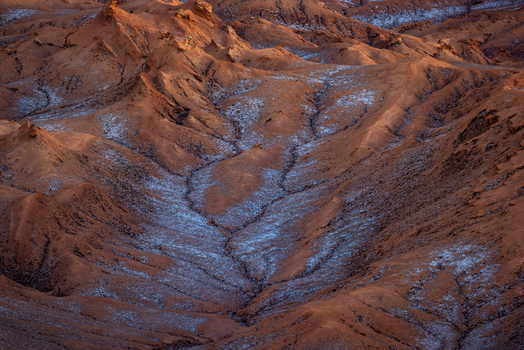 Aerial view of the rugged desert landscape of the Valley of the Moon with salt crusted terrain and dramatic shadows in San Pedro de Atacama Antofagasta Chile. Aerial view of the rugged desert landscape of the Valley of the Moon with salt crusted terrain and dramatic shadows in San Pedro de Atacama Antofagasta Chile.