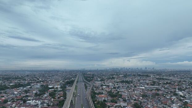 Aerial view of the highway and railway infrastructure cutting through the dense urban landscape of Bekasi Barat West Java Indonesia.