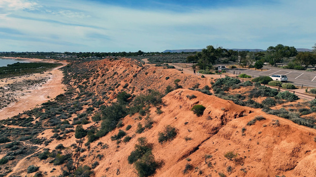 Aerial view of Matthew Flinders Red Cliff Lookout featuring red cliffs coastal vegetation a parking area and a blue sky in Port Augusta West South Australia Australia. Aerial view of Matthew Flinders Red Cliff Lookout featuring red cliffs coastal vegetation a parking area and a blue sky in Port Augusta West South Australia Australia.