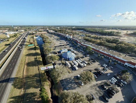 Aerial view of a bustling commercial area with a blue and white big top tent and a river running alongside a busy highway St. Augustine Florida United States. Aerial view of a bustling commercial area with a blue and white big top tent and a river running alongside a busy highway St. Augustine Florida United States.