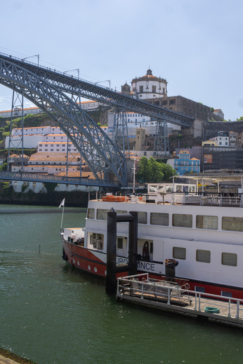 Aerial view of Dom Luís I Bridge s iron arches towering over the Douro River with boats docked along the vibrant Ribeira district Porto Porto District Portugal. Aerial view of Dom Luís I Bridge s iron arches towering over the Douro River with boats docked along the vibrant Ribeira district Porto Porto District Portugal.