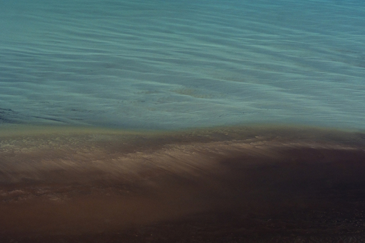 Aerial view of intricate ocean patterns with contrasting turquoise and dark sandy water along the coastline in Shire of Shark Bay Western Australia Australia. Aerial view of intricate ocean patterns with contrasting turquoise and dark sandy water along the coastline in Shire of Shark Bay Western Australia Australia.