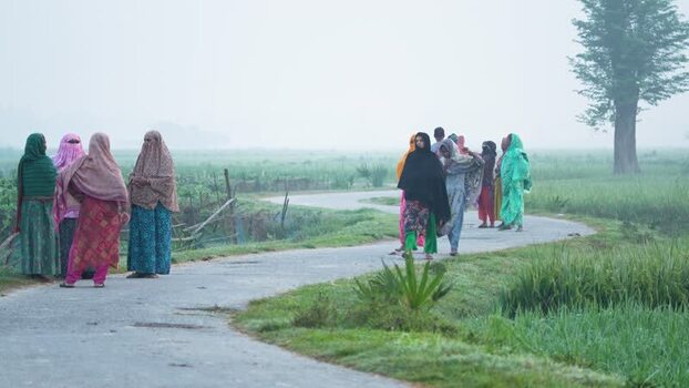 View of women walking on a rural road in Bogura Bangladesh.
