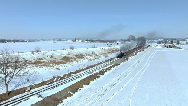 Aerial view of a steam train in a snowy landscape United States. Aerial view of a steam train in a snowy landscape United States.