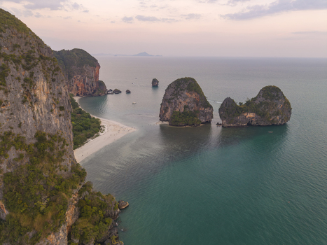 Aerial view of dramatic limestone cliffs plunging into the turquoise sea fringed by white sandy beaches Krabi Thailand. Aerial view of dramatic limestone cliffs plunging into the turquoise sea fringed by white sandy beaches Krabi Thailand.