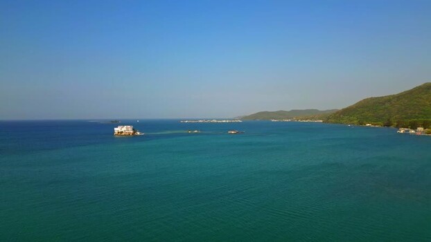 Aerial view of the turquoise sea and lush hills in Guanaja Honduras.