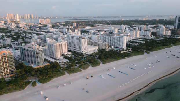 Aerial view of Miami Beach featuring white sandy beaches luxury hotels and high rise buildings along the coastline in Miami Beach Florida United States. Aerial view of Miami Beach featuring white sandy beaches luxury hotels and high rise buildings along the coastline in Miami Beach Florida United States.