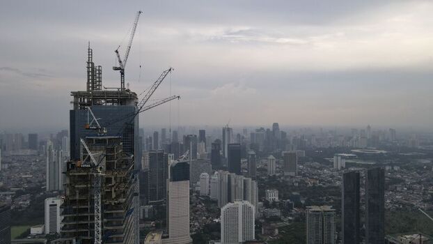 Kecamatan Menteng Indonesia 03 December 2021 Aerial view of a skyscraper under construction with tower cranes surrounded by the dense urban skyline of Jakarta Pusat. Kecamatan Menteng Indonesia 03 December 2021 Aerial view of a skyscraper under construction with tower cranes surrounded by the dense urban skyline of Jakarta Pusat.