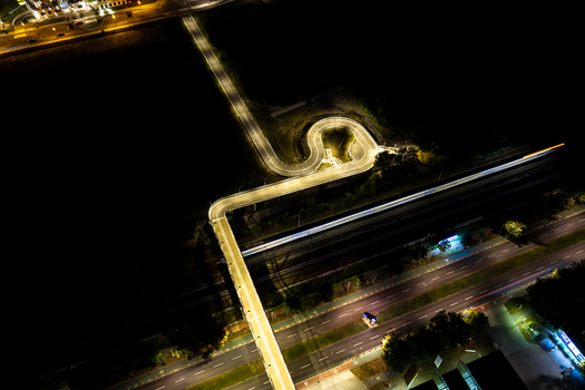 Aerial view of Hilde Archenhold Brucke illuminated at night featuring its distinctive winding pedestrian path crossing over railway tracks and a road in Berlin Berlin Germany. Aerial view of Hilde Archenhold Brucke illuminated at night featuring its distinctive winding pedestrian path crossing over railway tracks and a road in Berlin Berlin Germany.