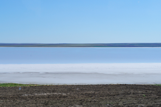 View of the vast white salt flats and calm blue waters of Lake Tuz under a clear sky in Ankara Ankara Turkiye. View of the vast white salt flats and calm blue waters of Lake Tuz under a clear sky in Ankara Ankara Turkiye.