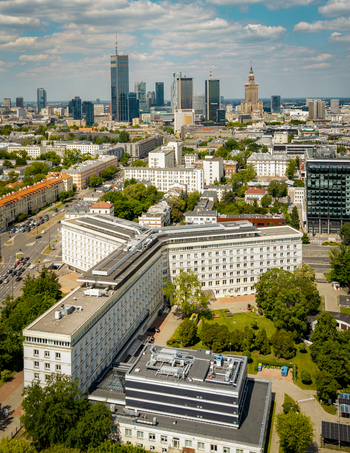 Aerial view of the Warsaw skyline featuring the Palace of Culture and Science modern skyscrapers and dense urban architecture under a blue sky with scattered clouds in Poland. Aerial view of the Warsaw skyline featuring the Palace of Culture and Science modern skyscrapers and dense urban architecture under a blue sky with scattered clouds in Poland.