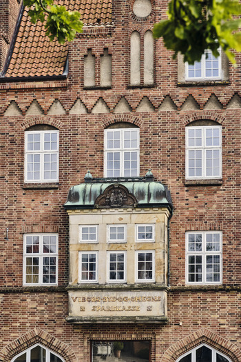 Viborg Denmark 07 August 2026 View of the historic facade of the old Viborg bank building featuring red brickwork a stone oriel window and symmetrical white framed windows. Viborg Denmark 07 August 2026 View of the historic facade of the old Viborg bank building featuring red brickwork a stone oriel window and symmetrical white framed windows.
