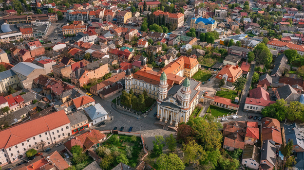 Aerial view of the Uzhhorod Greek Catholic Cathedral amidst a tapestry of terracotta roofs and verdant trees under a bright sky Uzhhorod Zakarpattia Oblast Ukraine. Aerial view of the Uzhhorod Greek Catholic Cathedral amidst a tapestry of terracotta roofs and verdant trees under a bright sky Uzhhorod Zakarpattia Oblast Ukraine.