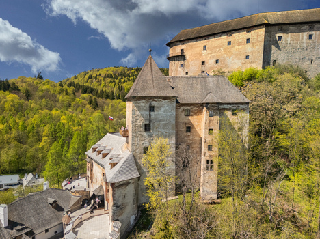 Aerial view of Orava Castle perched on a steep rock cliff surrounded by vibrant green spring forests and a blue sky Dolny Kubin Zilinsky kraj Slovakia. Aerial view of Orava Castle perched on a steep rock cliff surrounded by vibrant green spring forests and a blue sky Dolny Kubin Zilinsky kraj Slovakia.