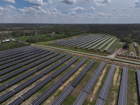Lebanon United States 12 April 2026 Aerial view of a large solar farm with rows of photovoltaic panels surrounded by green fields and trees under a cloudy sky.