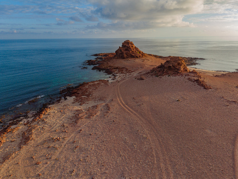 Aerial view of rugged sun baked cliffs meet the turquoise sea in a symphony of earth tones and coastal beauty Dhi Hamri Socotra Yemen. Aerial view of rugged sun baked cliffs meet the turquoise sea in a symphony of earth tones and coastal beauty Dhi Hamri Socotra Yemen.