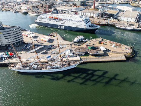 IJmuiden Netherlands 19 August 2025 Aerial view of the DFDS ferry and the Portuguese tall ship NRP Sagres docked in the harbor under a clear sky. IJmuiden Netherlands 19 August 2025 Aerial view of the DFDS ferry and the Portuguese tall ship NRP Sagres docked in the harbor under a clear sky.
