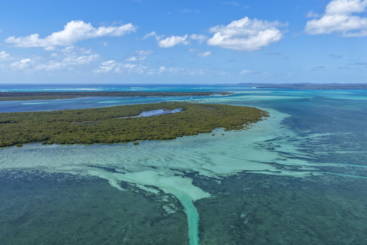 Aerial view of Moreton Island featuring lush mangrove forests surrounded by turquoise shallow waters and deep blue ocean in Kooringal Queensland Australia. Aerial view of Moreton Island featuring lush mangrove forests surrounded by turquoise shallow waters and deep blue ocean in Kooringal Queensland Australia.