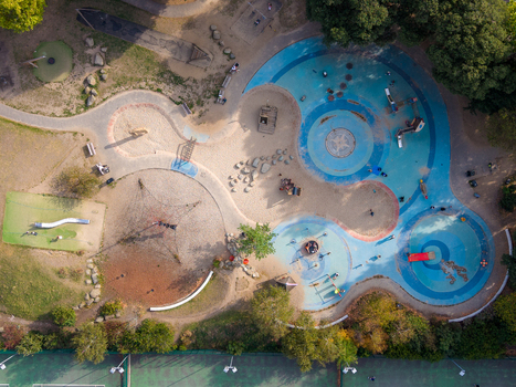 Aerial view of the colorful playground in Clissold Park with sand pits climbing frames and slides surrounded by trees in Stoke Newington London England United Kingdom. Aerial view of the colorful playground in Clissold Park with sand pits climbing frames and slides surrounded by trees in Stoke Newington London England United Kingdom.