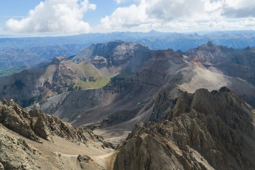 Aerial view of Mount Sneffels and the rugged peaks of the San Juan Mountains featuring rocky ridges and dramatic terrain in Ouray County Colorado United States. Aerial view of Mount Sneffels and the rugged peaks of the San Juan Mountains featuring rocky ridges and dramatic terrain in Ouray County Colorado United States.