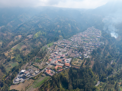 Aerial view of Wonokerto village nestled among lush green hills and agricultural fields in Sukorejo East Java Indonesia. Aerial view of Wonokerto village nestled among lush green hills and agricultural fields in Sukorejo East Java Indonesia.