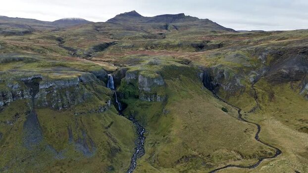 Aerial view of Bugsfoss waterfall and rocky hills Iceland.