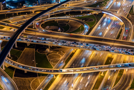 View of a complex multi level highway interchange at night with light trails from moving vehicles and illuminated circular ramps in Dubai Dubai United Arab Emirates. View of a complex multi level highway interchange at night with light trails from moving vehicles and illuminated circular ramps in Dubai Dubai United Arab Emirates.