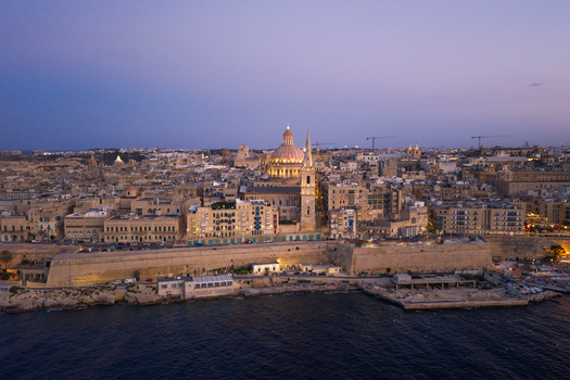 Aerial view of the historic skyline of Valletta featuring the dome of the Basilica of Our Lady of Mount Carmel and St. Paul s Pro Cathedral at dusk in Valletta Port Region Malta. Aerial view of the historic skyline of Valletta featuring the dome of the Basilica of Our Lady of Mount Carmel and St. Paul s Pro Cathedral at dusk in Valletta Port Region Malta.