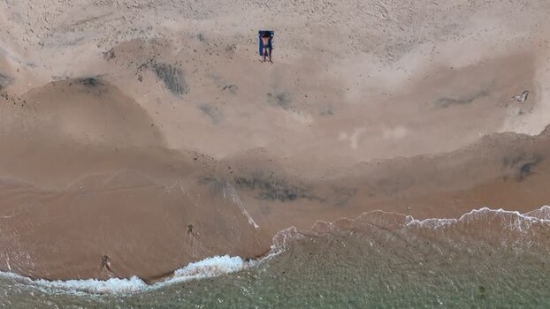Aerial view of a person sunbathing on a sandy beach Portugal. Aerial view of a person sunbathing on a sandy beach Portugal.