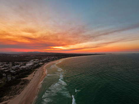 Aerial view of Kingscliff coastline at sunset with vibrant orange and red clouds over the ocean and sandy beach in Kingscliff New South Wales Australia. Aerial view of Kingscliff coastline at sunset with vibrant orange and red clouds over the ocean and sandy beach in Kingscliff New South Wales Australia.