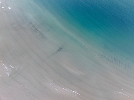Aerial view of the sandy beach and turquoise waters of Gruinard Bay with gentle ripples and waves Gruinard Scotland United Kingdom. Aerial view of the sandy beach and turquoise waters of Gruinard Bay with gentle ripples and waves Gruinard Scotland United Kingdom.