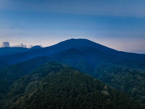 Aerial view of Goalpara Tea Park surrounded by dense forest and mountain ranges under a clear blue sky in Kecamatan Sukaraja Jawa Barat Indonesia. Aerial view of Goalpara Tea Park surrounded by dense forest and mountain ranges under a clear blue sky in Kecamatan Sukaraja Jawa Barat Indonesia.
