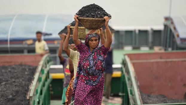 View of workers carrying coal baskets in Aminbazar Bangladesh. View of workers carrying coal baskets in Aminbazar Bangladesh.