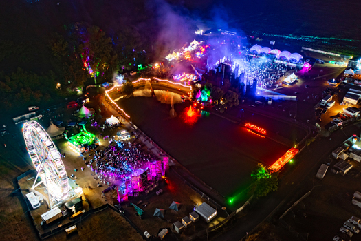 Herzogenaurach Germany 22 July 2022 Aerial view of the Open Beatz Festival at night with a lit ferris wheel colorful stages and crowds of people under vibrant lights. Herzogenaurach Germany 22 July 2022 Aerial view of the Open Beatz Festival at night with a lit ferris wheel colorful stages and crowds of people under vibrant lights.