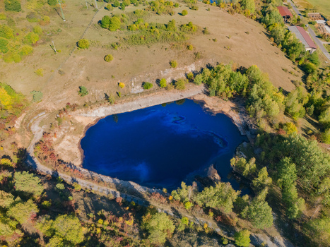 Aerial view of the Gudronove jamy acid tar lagoons surrounded by lush forest and hilly terrain near Predajna Banskobystricky kraj Slovakia. Aerial view of the Gudronove jamy acid tar lagoons surrounded by lush forest and hilly terrain near Predajna Banskobystricky kraj Slovakia.