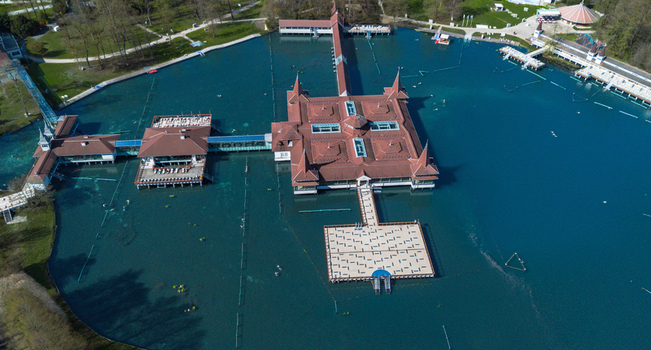Aerial view of the vibrant turquoise waters embrace the iconic red roofed buildings of H&eacute;v&iacute;z Lake creating a striking contrast against the surrounding lush greenery H&eacute;v&iacute;z Zala Hungary.