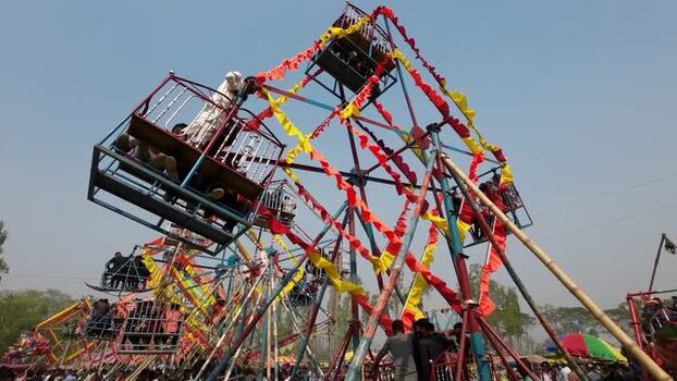 View of a traditional Ferris wheel with colorful ribbons Bangladesh. View of a traditional Ferris wheel with colorful ribbons Bangladesh.