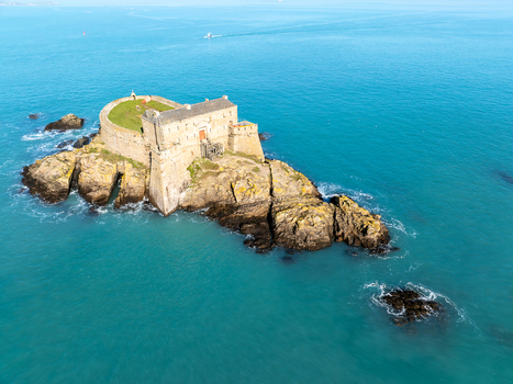 Aerial view of Fort du Petit Bé a stone fortress on a rocky islet surrounded by the turquoise sea standing resolute against the tides Saint Malo Bretagne France. Aerial view of Fort du Petit Bé a stone fortress on a rocky islet surrounded by the turquoise sea standing resolute against the tides Saint Malo Bretagne France.
