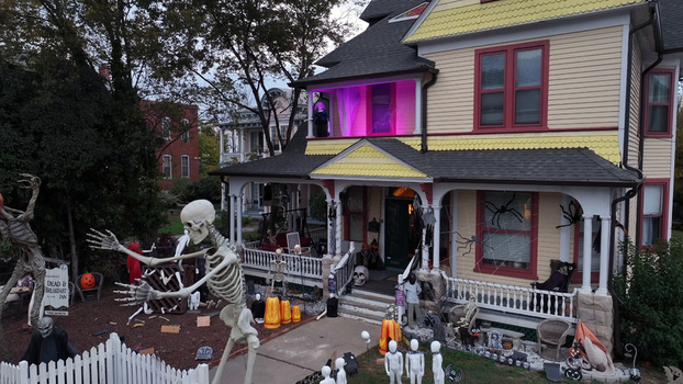 Aerial view of a historic house decorated for Halloween with life sized skeletons spider webs and pumpkins on the front lawn in Danville Virginia United States.
