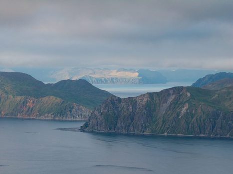 Aerial view of the rugged coastal mountains and deep blue waters of the Aleutian Islands in Unalaska Alaska United States.