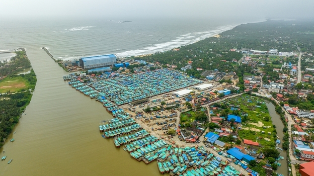 Aerial view of Malpe Fishing Harbour with hundreds of colorful fishing boats docked along the riverbank surrounded by lush greenery and coastal infrastructure in Udupi Karnataka India. Aerial view of Malpe Fishing Harbour with hundreds of colorful fishing boats docked along the riverbank surrounded by lush greenery and coastal infrastructure in Udupi Karnataka India.