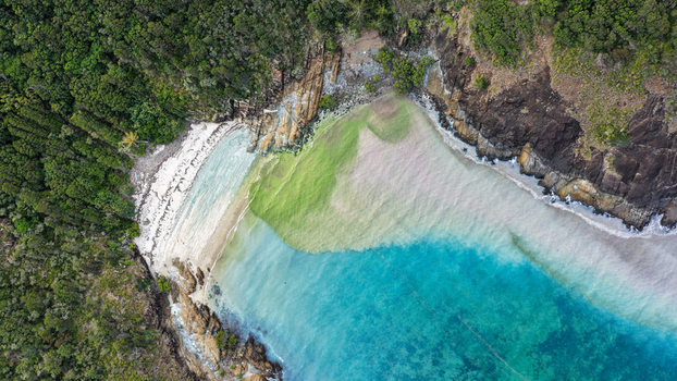 Aerial view of Chance Bay with turquoise waters sandy beach rocky cliffs and dense tropical forest in Whitsundays Queensland Australia. Aerial view of Chance Bay with turquoise waters sandy beach rocky cliffs and dense tropical forest in Whitsundays Queensland Australia.