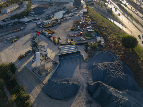 Aerial view of an industrial concrete plant featuring gravel piles storage silos and a fleet of parked trucks near a highway in Izmit Kocaeli Turkey. Aerial view of an industrial concrete plant featuring gravel piles storage silos and a fleet of parked trucks near a highway in Izmit Kocaeli Turkey.