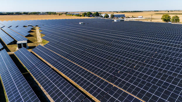 Aerial view of a large solar farm with rows of photovoltaic panels installed in a rural landscape under a clear blue sky in Temerin Vojvodina Serbia. Aerial view of a large solar farm with rows of photovoltaic panels installed in a rural landscape under a clear blue sky in Temerin Vojvodina Serbia.