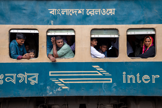 Dhaka Bangladesh 14 June 2018 View of people looking out of the windows of a blue Bangladesh Railway train carriage at Airport Railway Station. Dhaka Bangladesh 14 June 2018 View of people looking out of the windows of a blue Bangladesh Railway train carriage at Airport Railway Station.