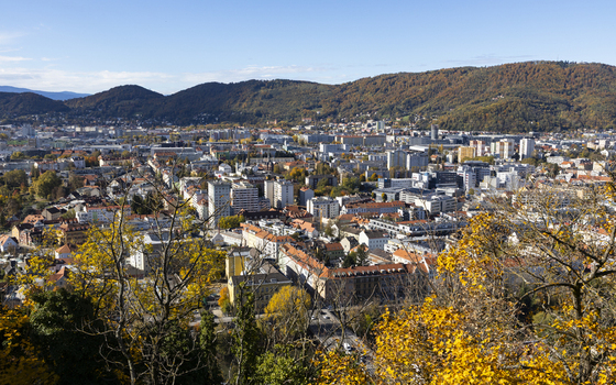View of autumn tints paint the cityscape with golden hues nestled amidst rolling hills under a crisp blue sky a captivating panorama Graz Styria Austria. View of autumn tints paint the cityscape with golden hues nestled amidst rolling hills under a crisp blue sky a captivating panorama Graz Styria Austria.