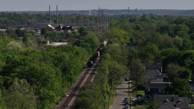 Aerial view of a freight train moving through trees United States. Aerial view of a freight train moving through trees United States.